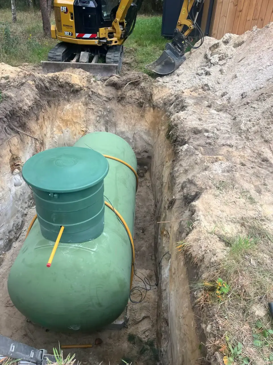 Zielony zbiornik podziemny w wykopie przed zasypaniem